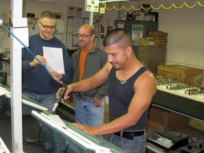 Three Men Operating A Machine On Massager